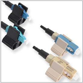 Four AFL FASTConnectors a beige SC connector with a black 900um boot sitting in a beige holding clip a blue SC connector in a beige holding clip with a black 900um boot.  A blue LC connector in a black holding clip with a black 900um boot and an aqua LC c